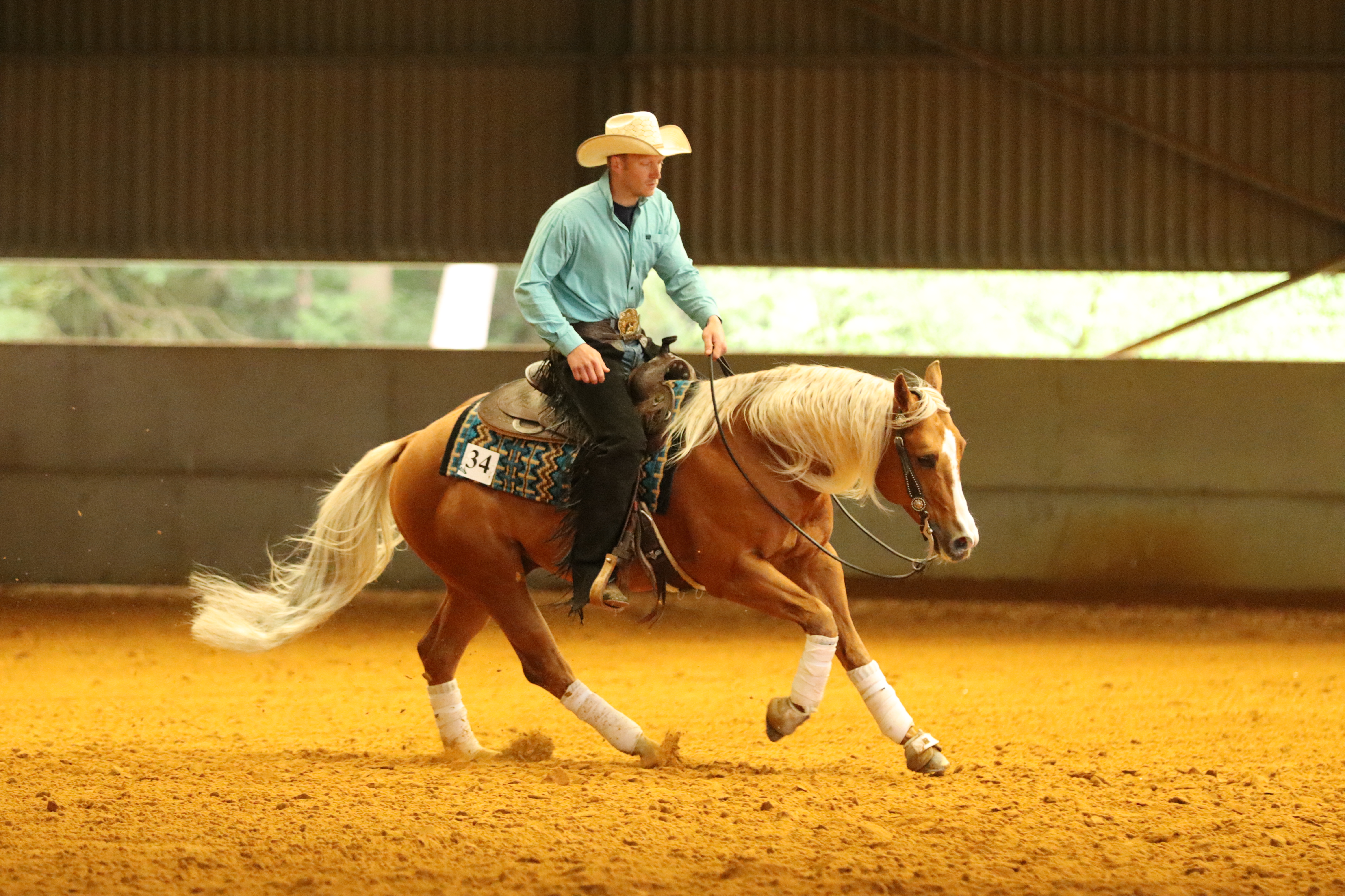 Man cantering with his horse during a western riding competition.